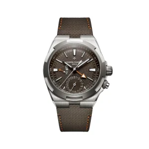 Reloj de lujo Vacheron Constantin Overseas Dual Time con esfera marrón texturizada, aguja GMT con punta de flecha naranja, subesfera de fecha y correa estructurada marrón con pespuntes naranjas.